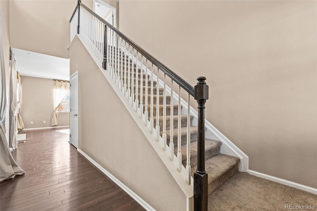 staircase featuring hardwood / wood-style floors and a high ceiling