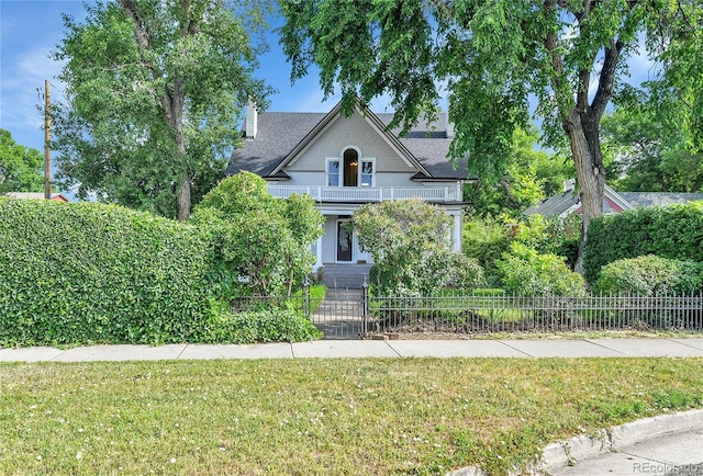 7011 Grandview Ave, Arvada, CO 80002 - victorian house with a fenced front yard, a balcony, a gate, and a chimney