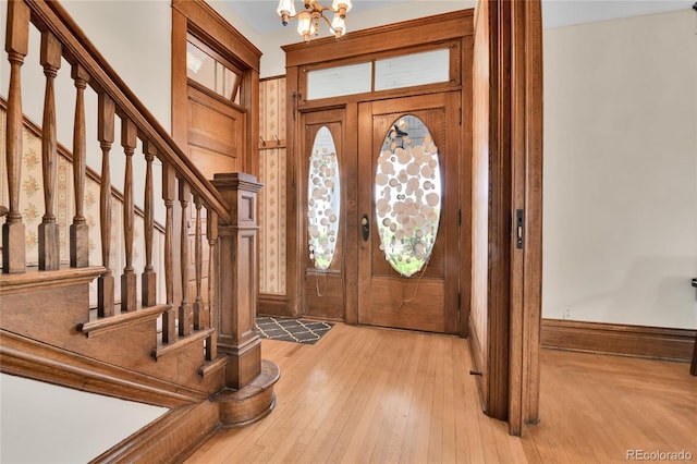 7011 Grandview Ave, Arvada, CO 80002 - foyer featuring a chandelier, stairs, and light wood-style flooring