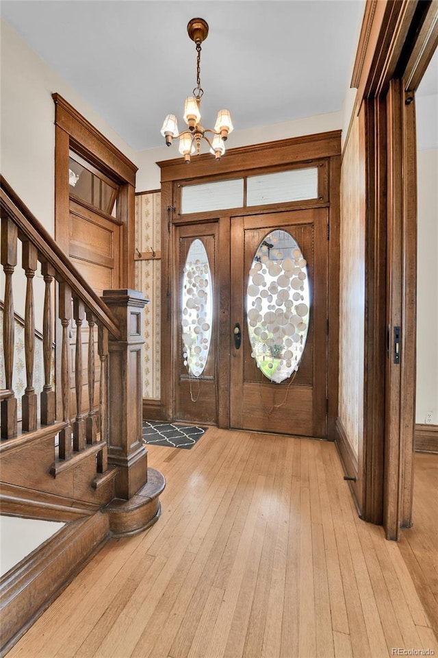 7011 Grandview Ave, Arvada, CO 80002 - foyer entrance with a chandelier, light wood-style floors, and stairway