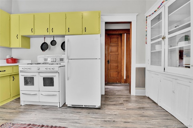 7011 Grandview Ave, Arvada, CO 80002 - kitchen featuring white appliances, yellow cabinetry, light wood-style flooring, and light countertops
