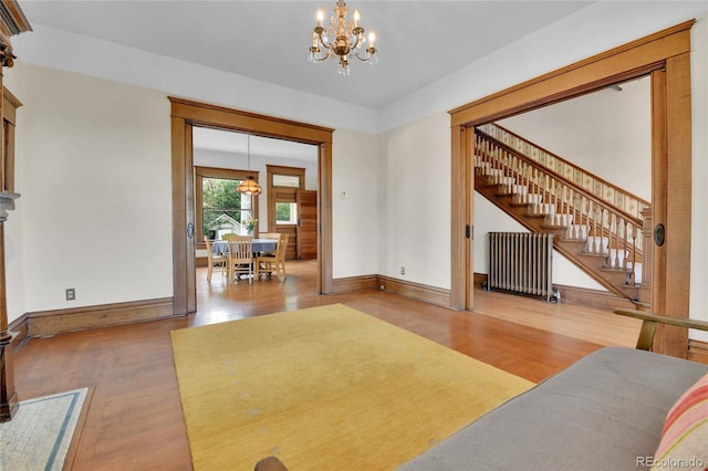 7011 Grandview Ave, Arvada, CO 80002 - living area featuring radiator, a chandelier, wood finished floors, and stairway