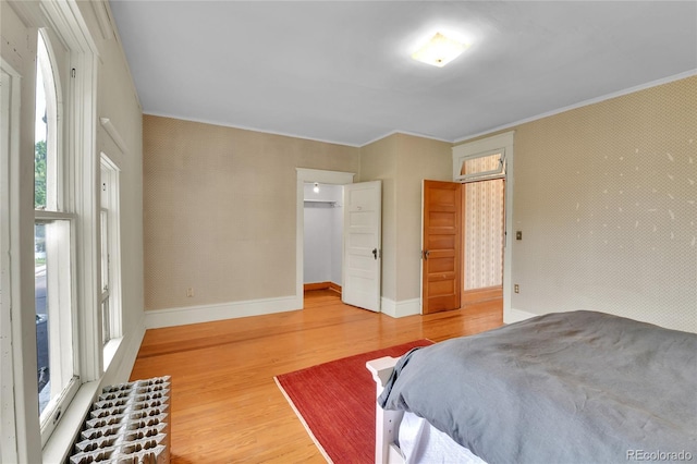 7011 Grandview Ave, Arvada, CO 80002 - bedroom featuring wood finished floors, ornamental molding, multiple windows, and a closet