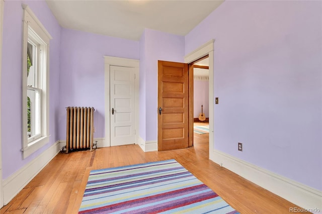 7011 Grandview Ave, Arvada, CO 80002 - bedroom featuring radiator heating unit, light wood-type flooring, and multiple windows