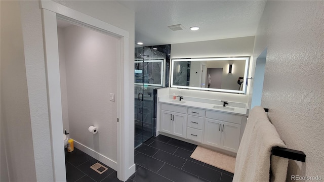 bathroom with a shower with shower door, tile patterned floors, and double sink vanity