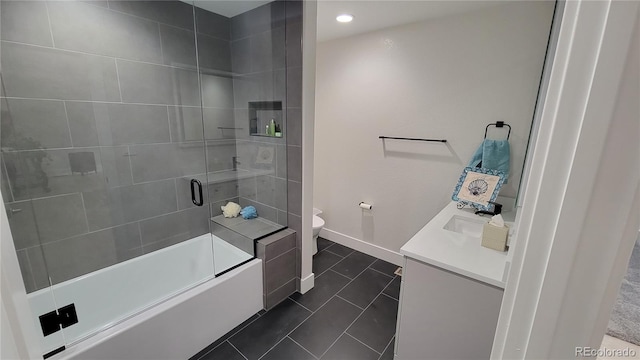 full bathroom with tile patterned flooring, shower / bath combination with glass door, toilet, and vanity