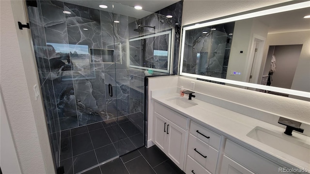 bathroom with tile patterned floors, double sink vanity, and walk in shower