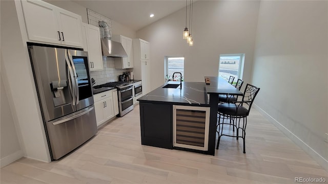 kitchen featuring white cabinetry, appliances with stainless steel finishes, wine cooler, and an island with sink