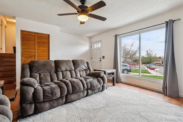16533 E Baker Pl, Aurora, CO 80013 - living room featuring a textured ceiling, a ceiling fan, and light wood-type flooring