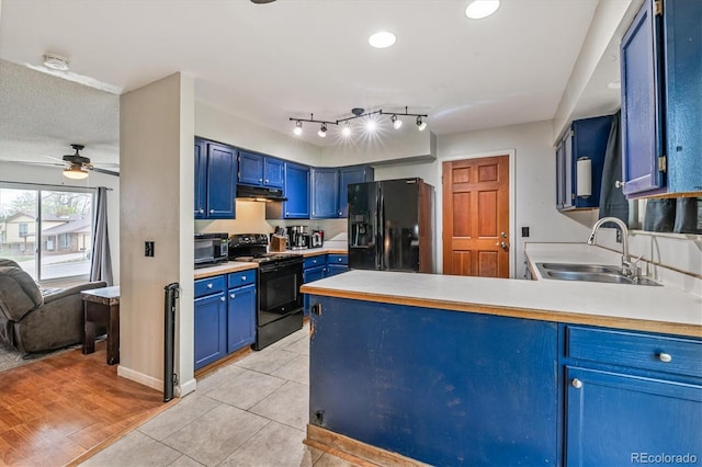 16533 E Baker Pl, Aurora, CO 80013 - kitchen with black appliances, blue cabinets, a peninsula, under cabinet range hood, and light countertops