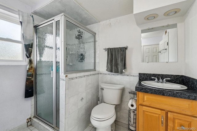 16533 E Baker Pl, Aurora, CO 80013 - bathroom with vanity, a stall shower, tile walls, and tile patterned flooring