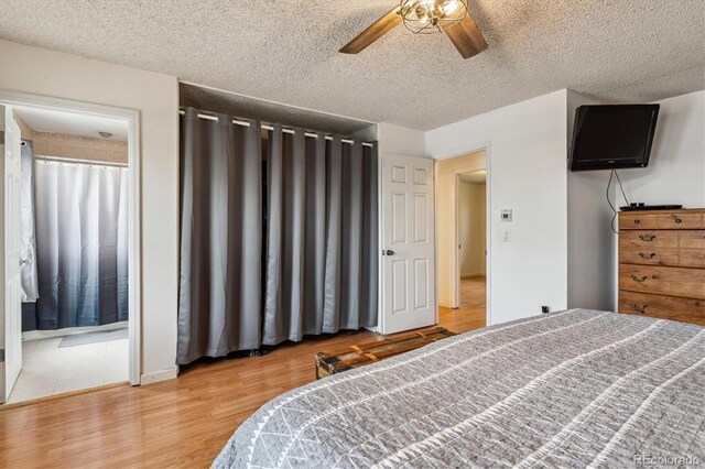 16533 E Baker Pl, Aurora, CO 80013 - bedroom with a textured ceiling, wood finished floors, a ceiling fan, and connected bathroom