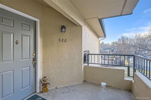 view of exterior entry with a balcony