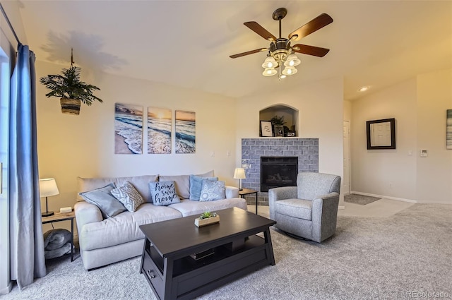 carpeted living room featuring a brick fireplace and ceiling fan