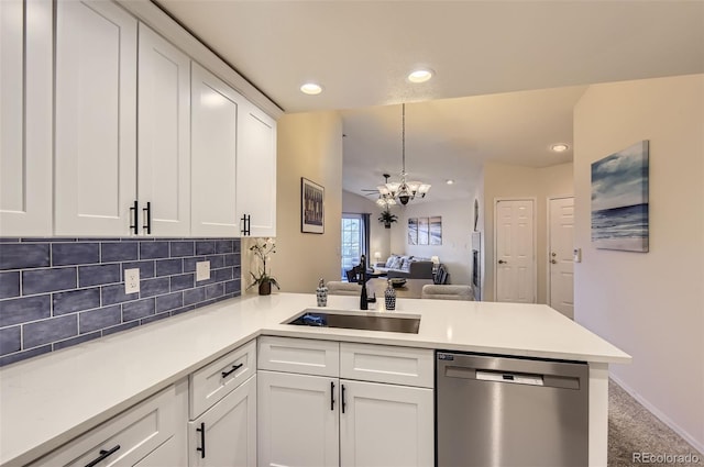 kitchen featuring sink, white cabinets, carpet, stainless steel dishwasher, and kitchen peninsula