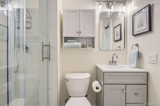 bathroom with vanity, toilet, and a shower with shower door