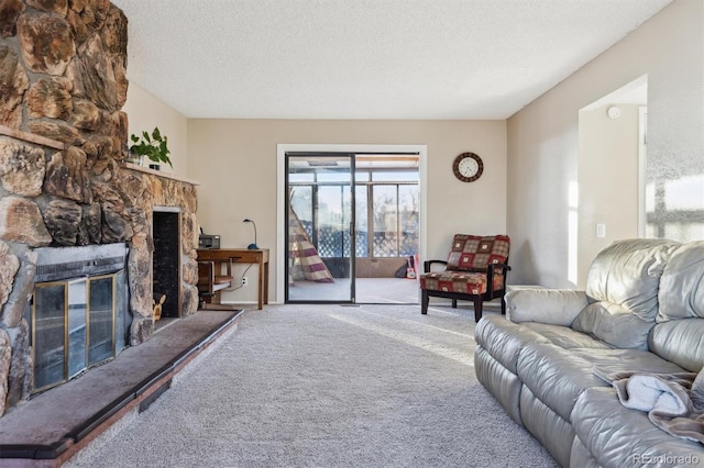 carpeted living room with a textured ceiling and a fireplace