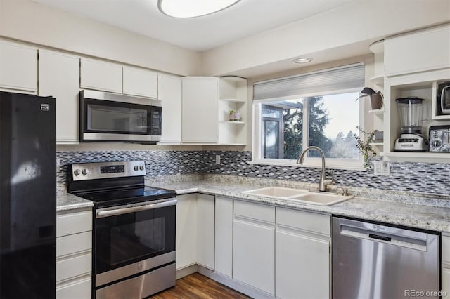 kitchen featuring appliances with stainless steel finishes, sink, white cabinets, backsplash, and dark wood-type flooring