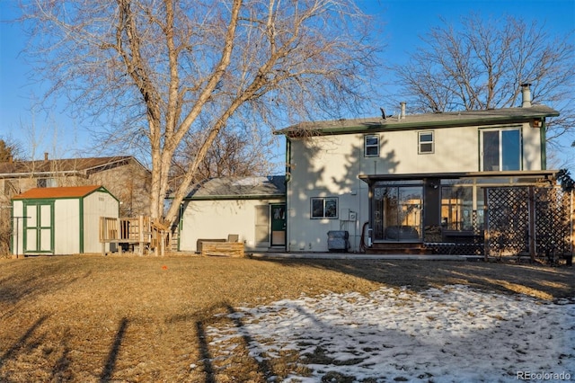 snow covered house featuring a storage shed and a sunroom