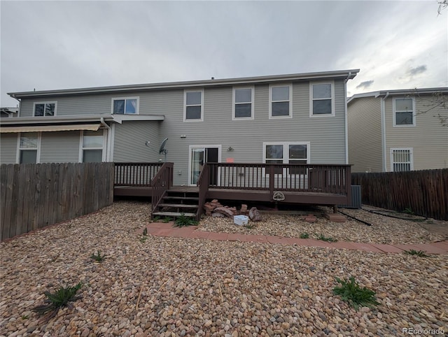 rear view of house with a fenced backyard and a deck