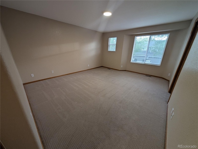 unfurnished room featuring light carpet, baseboards, and visible vents
