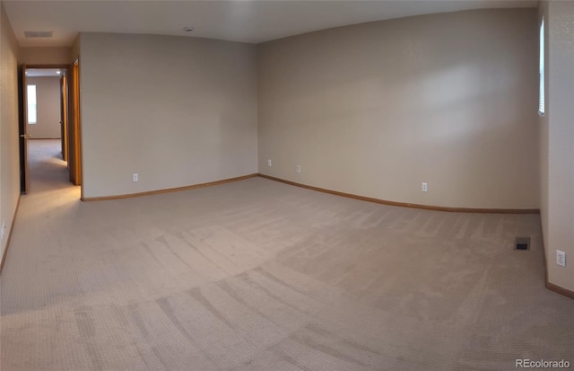 empty room featuring carpet flooring, visible vents, and baseboards