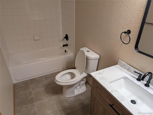 bathroom featuring toilet, vanity, shower / bath combination, and a textured wall