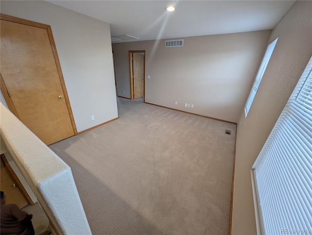 unfurnished room featuring baseboards, visible vents, and light colored carpet