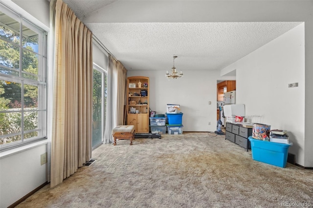 2742 S Xanadu Way, Aurora, CO 80014 - living area featuring a chandelier, a textured ceiling, carpet floors, and baseboards