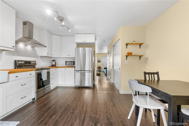 6776 S Independence St, Littleton, CO 80128 - kitchen featuring appliances with stainless steel finishes, tasteful backsplash, dark wood finished floors, butcher block counters, and wall chimney exhaust hood