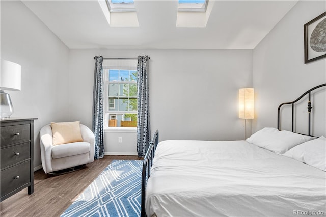6776 S Independence St, Littleton, CO 80128 - bedroom featuring a skylight, baseboards, and wood finished floors