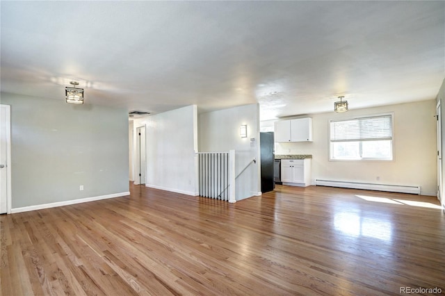 7704 Newland St, Arvada, CO 80003 - unfurnished living room with a baseboard radiator and light wood finished floors