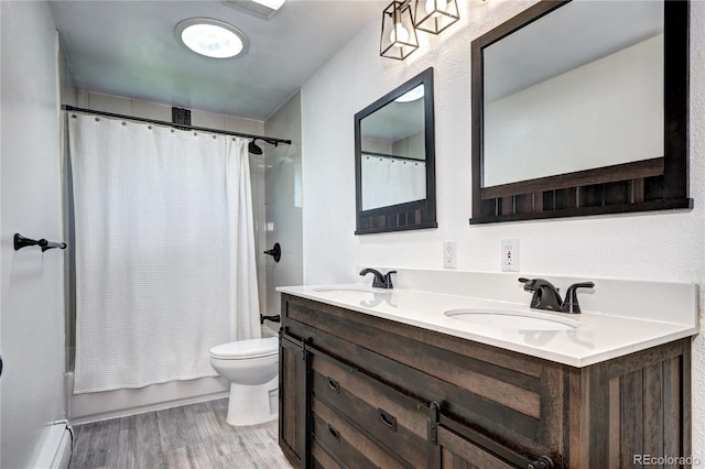 7704 Newland St, Arvada, CO 80003 - bathroom featuring a baseboard radiator, double vanity, wood finished floors, and shower / bath combo with shower curtain