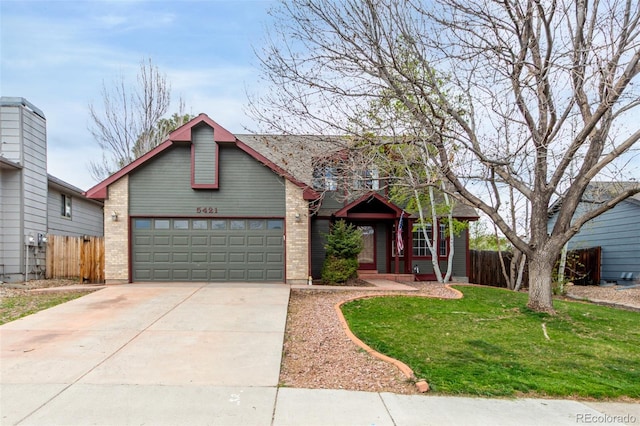 view of front of house with brick siding, driveway, a front lawn, and fence