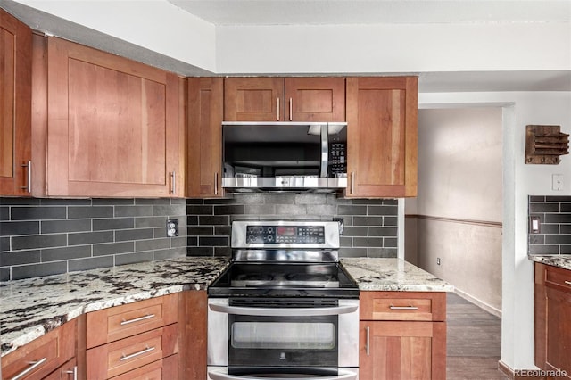 5421 S Vivian St, Littleton, CO 80127 - kitchen with stainless steel appliances, wood finished floors, light stone counters, brown cabinets, and decorative backsplash