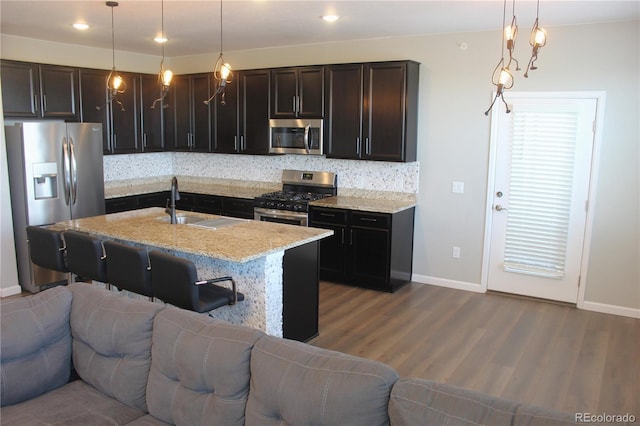 4680 Copeland Loop Unit 203, Highlands Ranch, CO 80126 - kitchen featuring stainless steel appliances, open floor plan, wood finished floors, backsplash, and recessed lighting