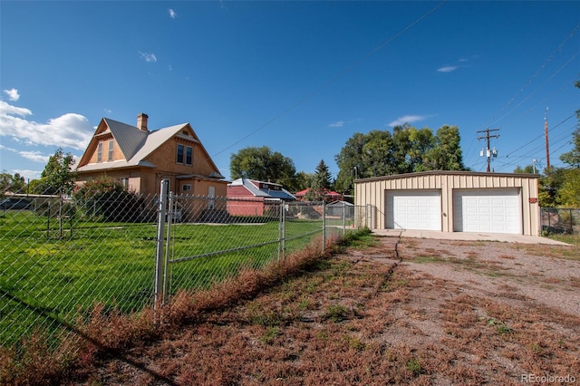 view of side of home with a garage, a yard, and an outbuilding