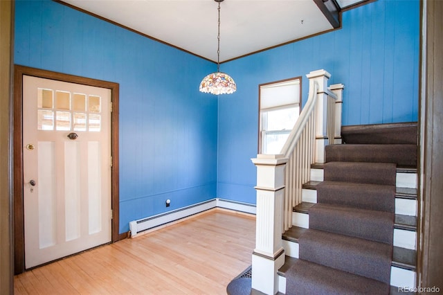 entryway featuring hardwood / wood-style flooring, crown molding, and a baseboard heating unit