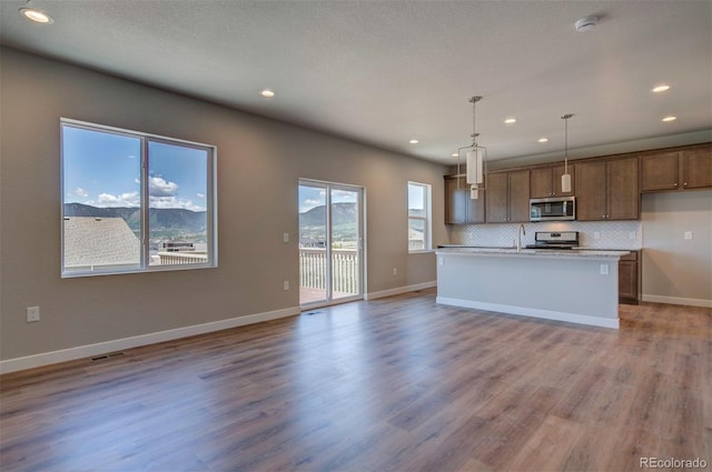 16858 Greyhawk Dr, Monument, CO 80132 - kitchen featuring open floor plan, recessed lighting, light countertops, appliances with stainless steel finishes, and hanging light fixtures
