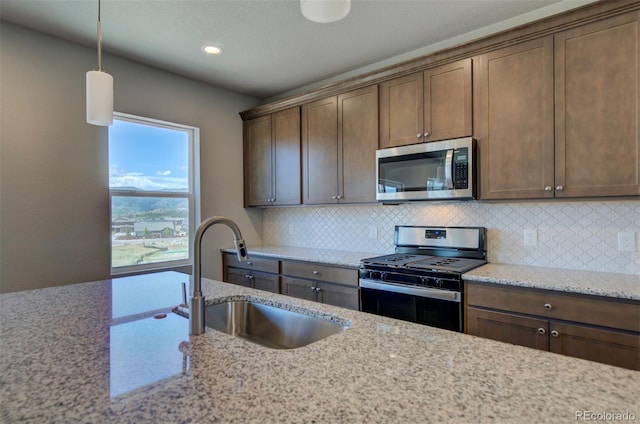 16858 Greyhawk Dr, Monument, CO 80132 - kitchen with a sink, appliances with stainless steel finishes, backsplash, and light stone countertops