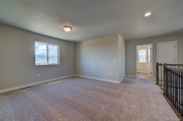16858 Greyhawk Dr, Monument, CO 80132 - spare room featuring light colored carpet, a textured ceiling, recessed lighting, baseboards, and visible vents