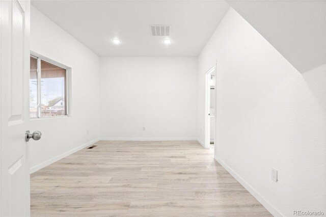 empty room featuring recessed lighting, light wood-style flooring, and baseboards