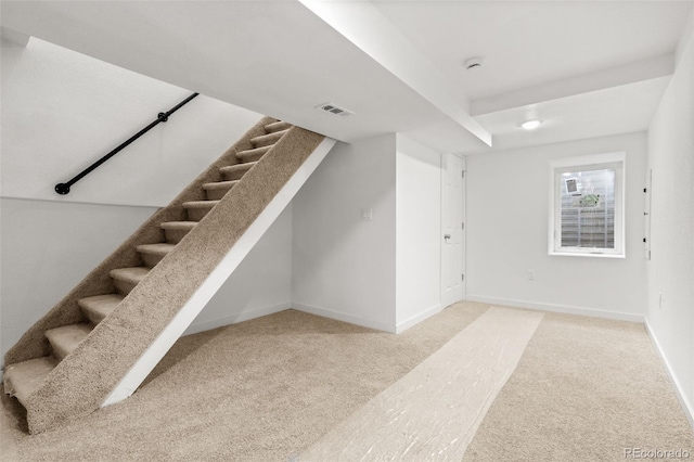 basement with carpet flooring, stairs, and baseboards