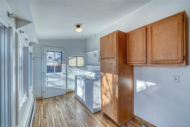 kitchen with wood walls, lofted ceiling, a baseboard heating unit, washing machine and dryer, and light hardwood / wood-style floors