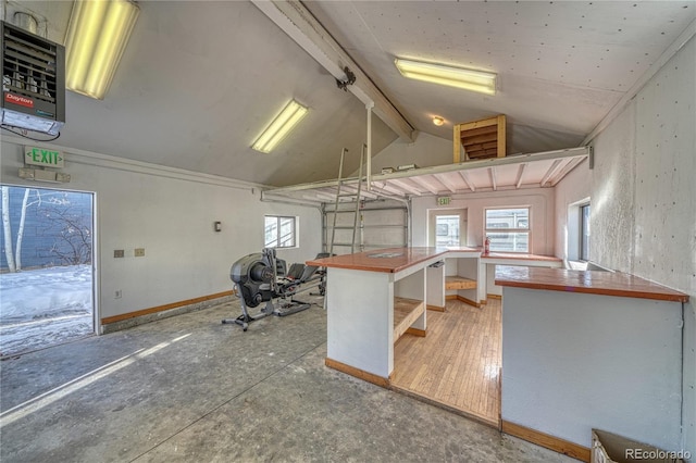 kitchen with a breakfast bar area, kitchen peninsula, hardwood / wood-style floors, and lofted ceiling with beams