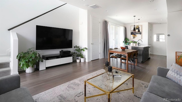 living area featuring a healthy amount of sunlight, visible vents, and dark wood finished floors