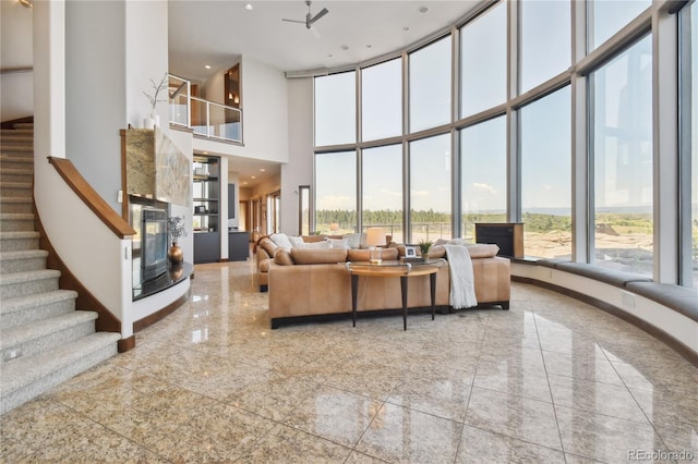 living room with a towering ceiling and ceiling fan