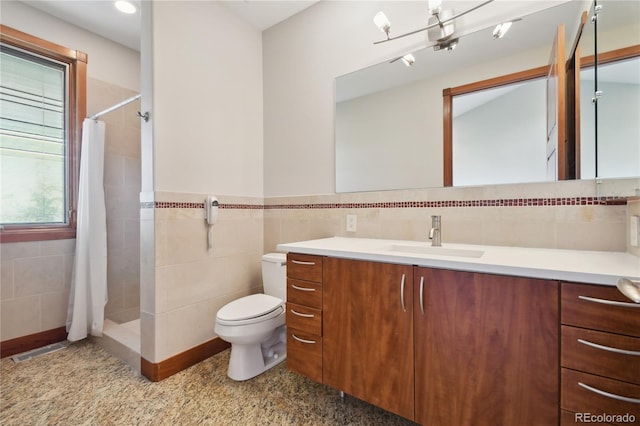 bathroom with a shower with shower curtain, vanity, toilet, and tile walls