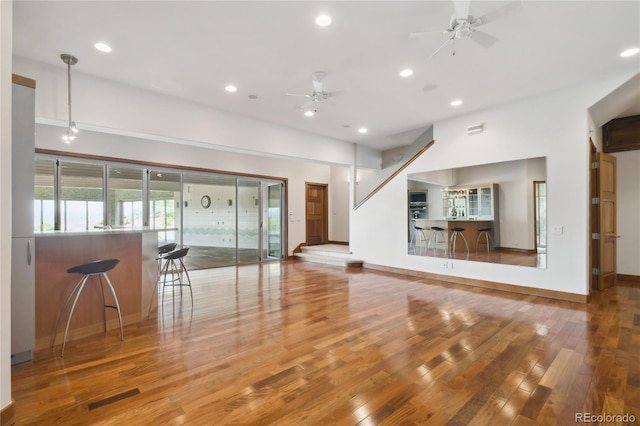 unfurnished living room featuring ceiling fan and light hardwood / wood-style flooring