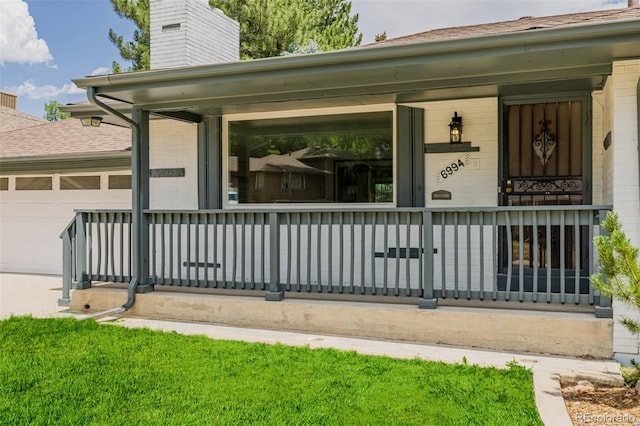 6994 Teller Ct, Arvada, CO 80003 - entrance to property featuring covered porch, a chimney, a garage, and brick siding